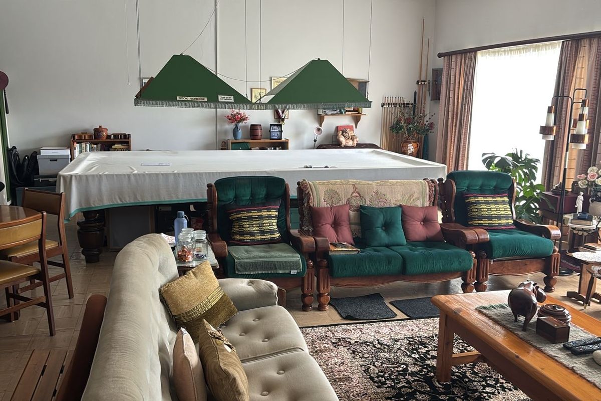 Spacious living area featuring tiled flooring and large windows, currently utilized as a multi-purpose recreational space.
