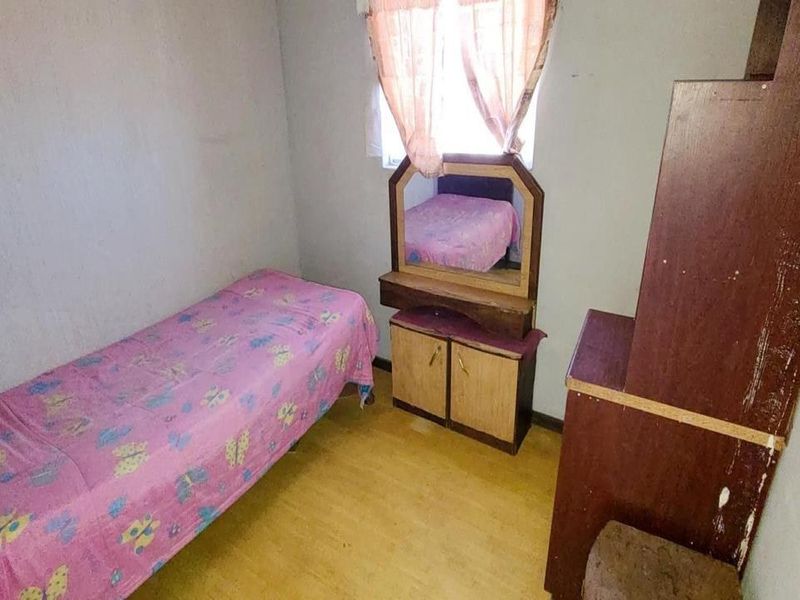A compact bedroom featuring basic finishes, suitable for a single bed setup.