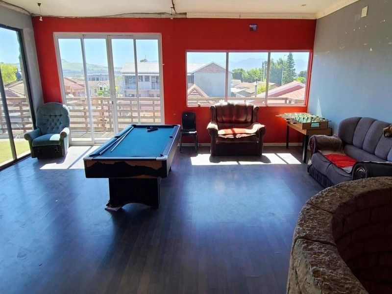 Spacious living area featuring large windows, sliding glass doors, and a stone feature, offering potential for a modern entertainment or lounge space.