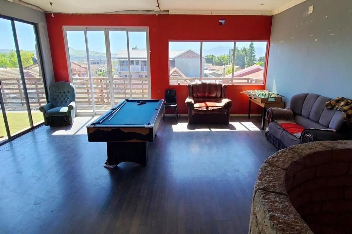 Spacious living area featuring large windows, sliding glass doors, and a stone feature, offering potential for a modern entertainment or lounge space.