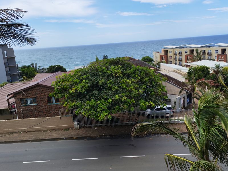 Elevated coastal view overlooking the surrounding neighborhood, street, and ocean horizon.