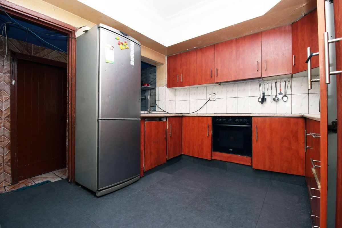 A functional kitchen featuring wood-tone cabinetry, tiled backsplash, and built-in oven, offering potential for modernization and aesthetic updates.