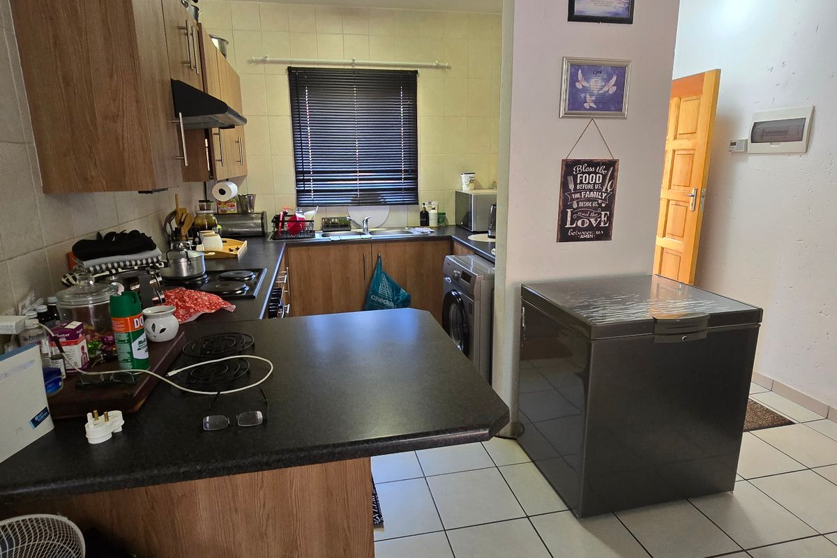 Functional kitchen featuring laminate cabinetry, tiled backsplash, and a breakfast nook counter, providing a practical workspace with integrated hob and extractor fan.