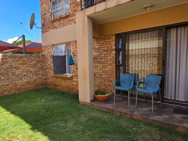 Ground floor apartment featuring a private garden, tiled patio area, and face brick exterior with sliding door access.