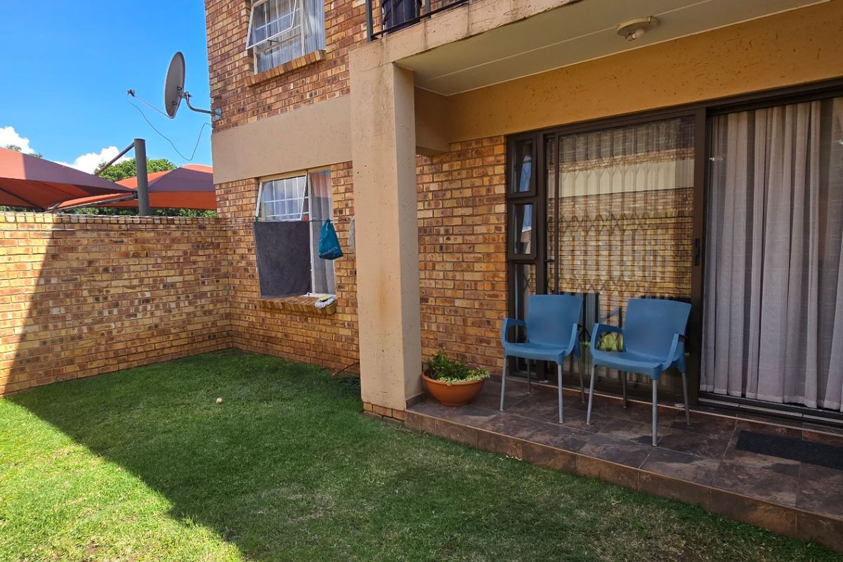 Ground floor apartment featuring a private garden, tiled patio area, and face brick exterior with sliding door access.