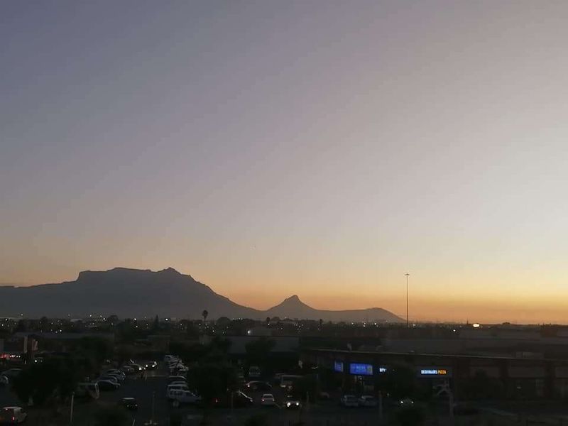 A scenic sunset view overlooking the surrounding neighbourhood with Table Mountain visible in the distance.