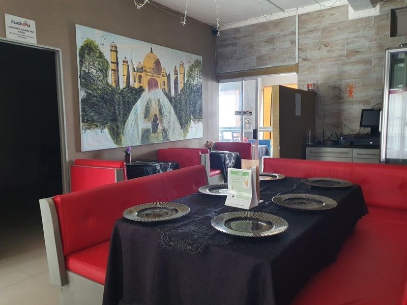 Dining area featuring booth-style seating, tiled wall accents, and access to an outdoor space through a sliding glass door.