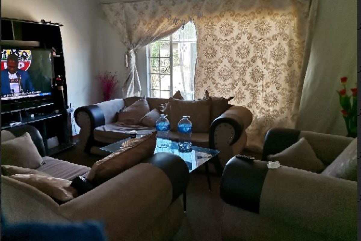 A living room area featuring a window with curtains, providing a functional space for relaxation.
