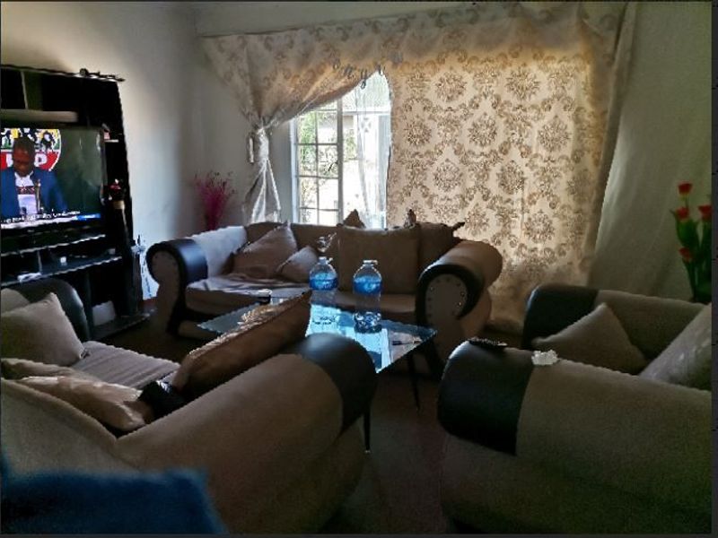 A living room area featuring a window with curtains, providing a functional space for relaxation.