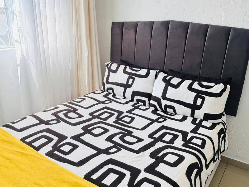 A bedroom featuring tiled flooring and a window with curtain tracks, providing a functional space for rest.