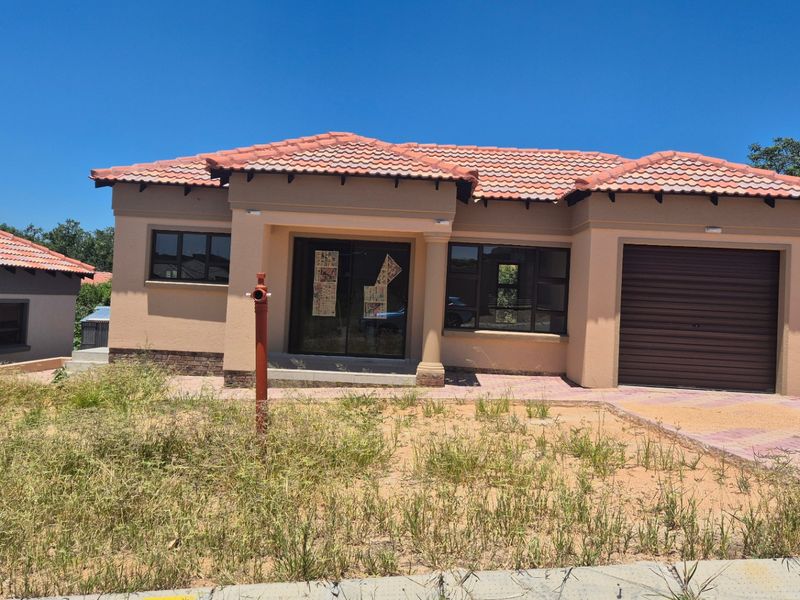 Front elevation of a modern single-story house featuring a tiled roof, integrated garage, and paved driveway, set on an unlandscaped plot.