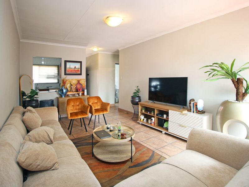 A comfortable living room featuring tiled flooring and neutral wall finishes, providing a functional and inviting space for relaxation.