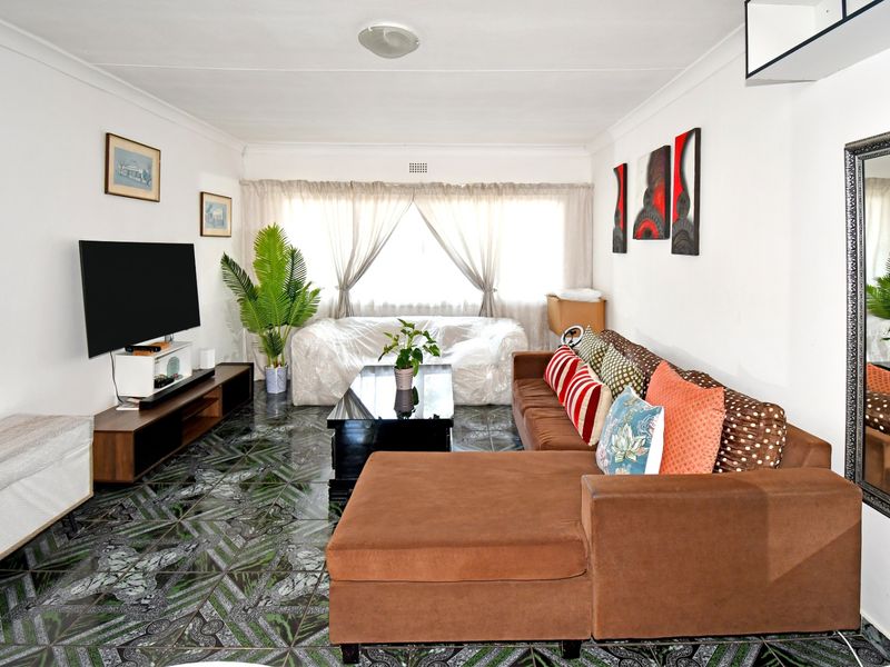 A living room featuring patterned tiled flooring and coved ceilings, providing a functional space for relaxation.