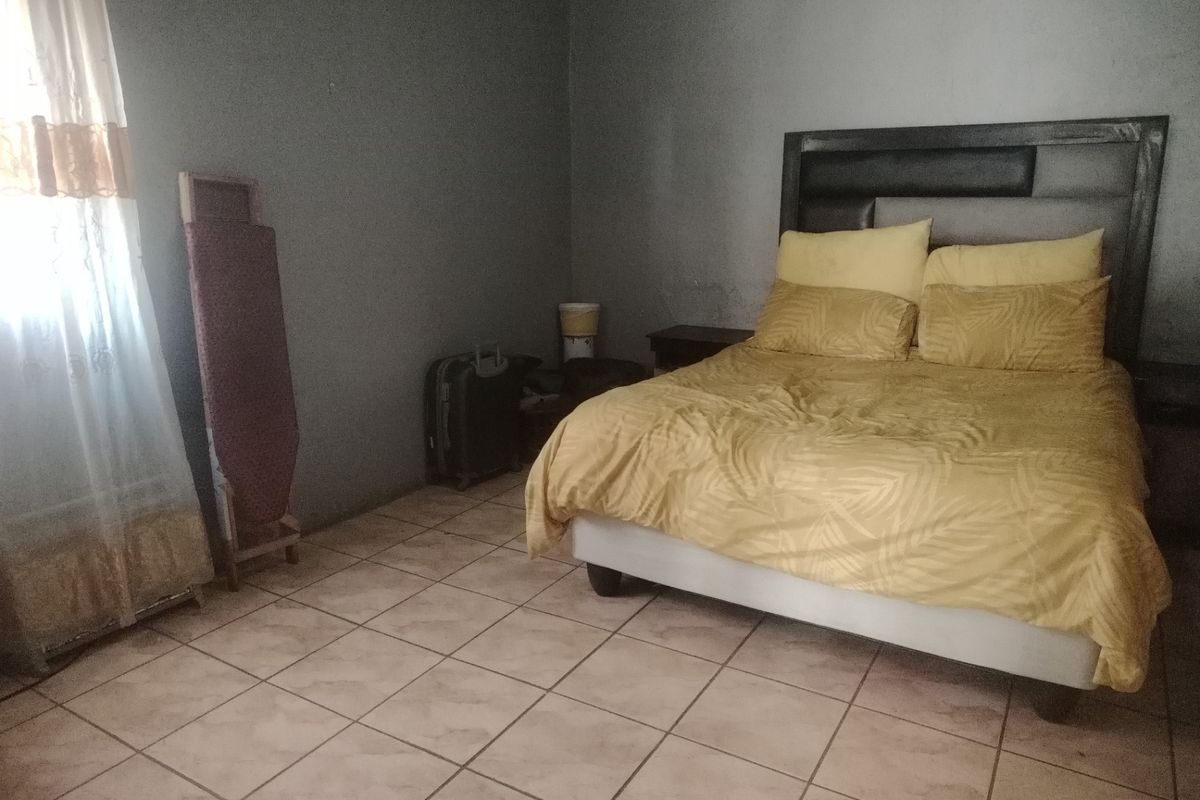 A bedroom featuring tiled flooring and neutral wall finishes, providing a functional space ready for cosmetic updates.