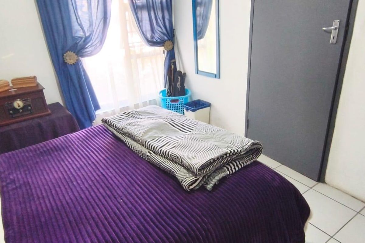A bedroom featuring tiled flooring and a standard interior door, providing a functional living space.