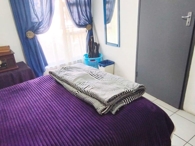 A bedroom featuring tiled flooring and a standard interior door, providing a functional living space.
