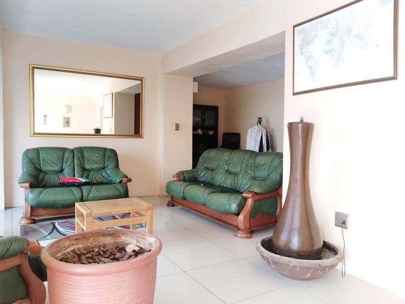 Spacious living area featuring neutral wall tones and large format floor tiles, offering a versatile layout for comfortable family living.