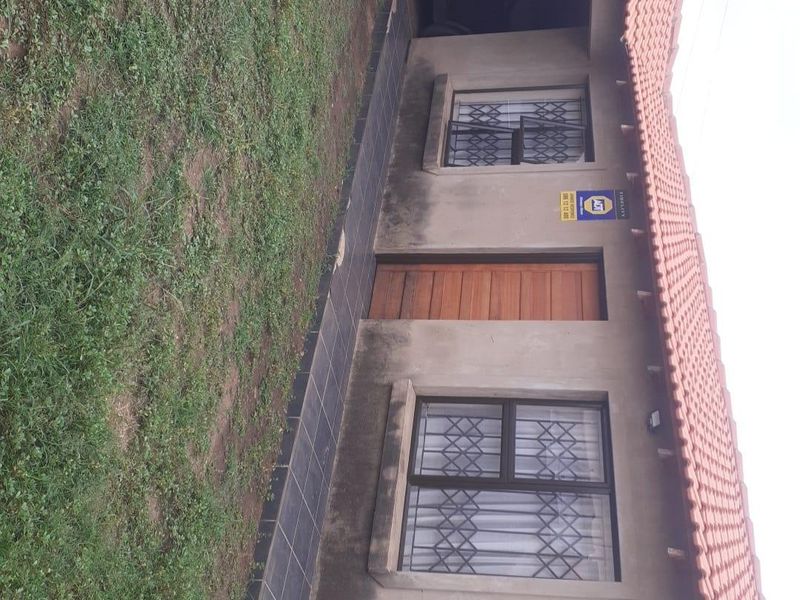 Front exterior view of the house featuring a tiled roof, security gates on windows, and a tiled walkway leading to the entrance.