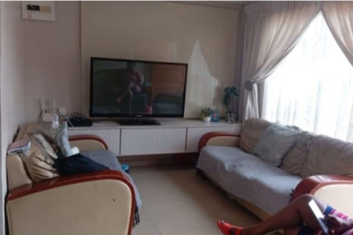 A living room featuring a built-in media console and tiled flooring, offering a functional space for relaxation.