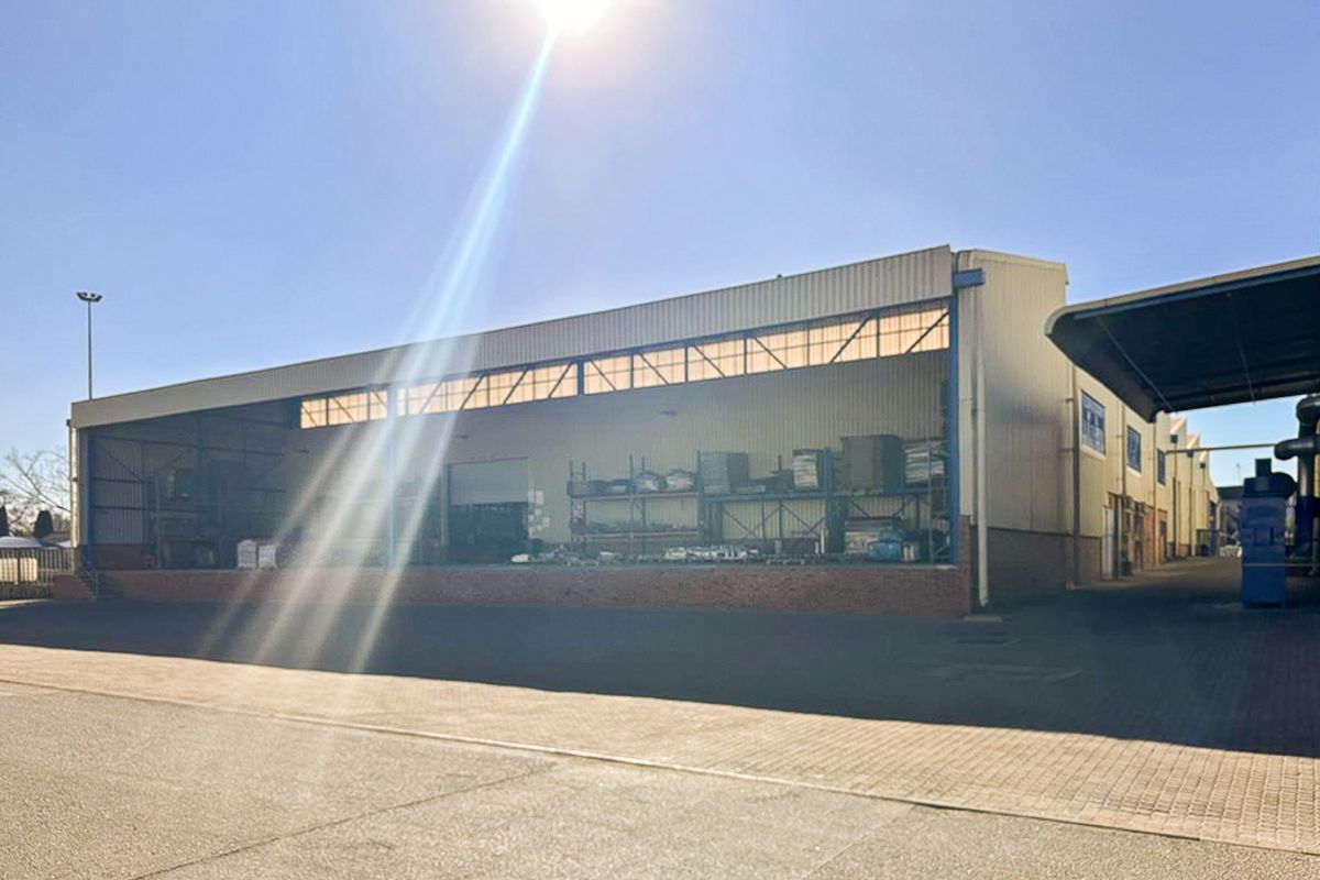 Industrial warehouse facility featuring a raised loading dock, metal cladding exterior, and paved yard area suitable for logistics or storage operations.
