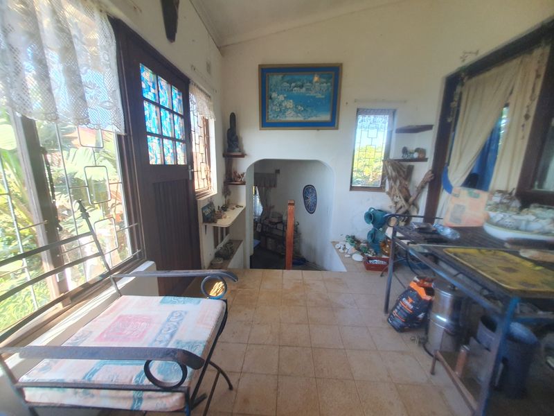 An entry area featuring tiled flooring, a stained glass door, and an arched transition leading to a lower level.