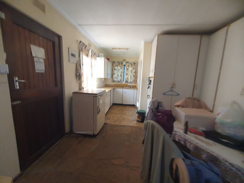 A dated kitchen area featuring built-in cabinetry and a sink, requiring modernization to improve functionality and aesthetic appeal.