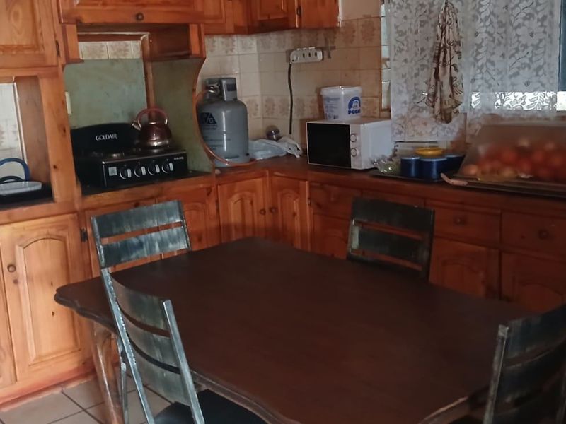 A dated kitchen featuring wooden cabinetry, tiled backsplash, and built-in cooking appliances, offering potential for a modern renovation.