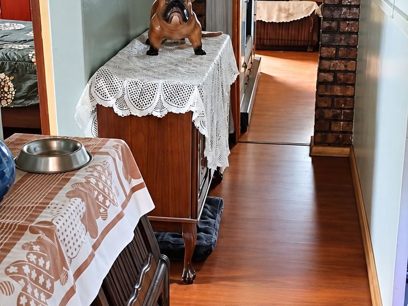 A hallway featuring a distinctive brick archway and wood-look laminate flooring, providing a transition between living spaces.