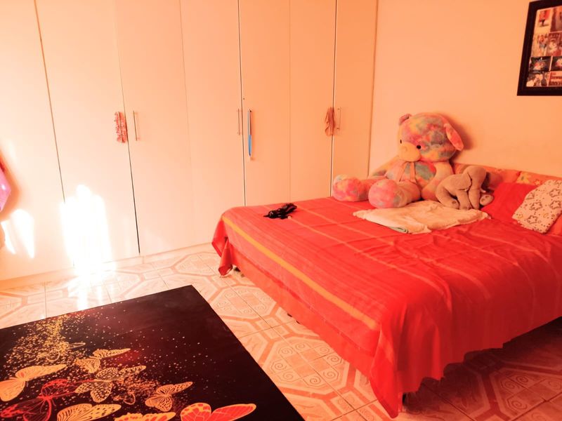 A bedroom featuring built-in floor-to-ceiling wardrobes and tiled flooring.
