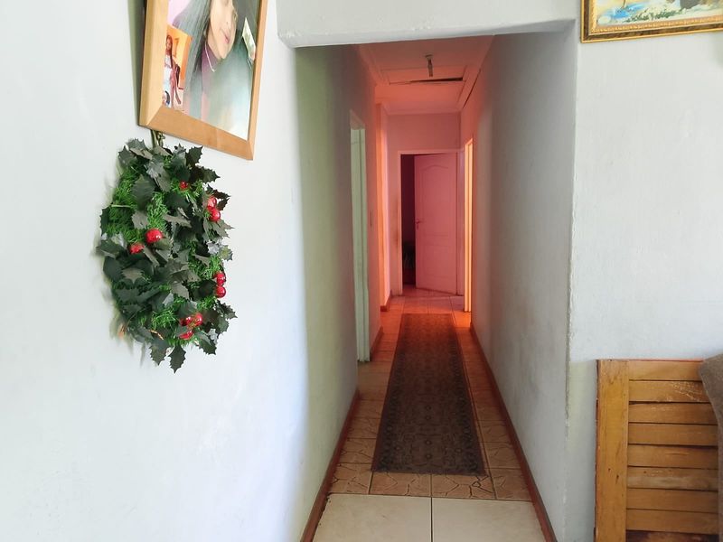A functional interior hallway connecting multiple rooms, featuring tiled flooring and standard door frames.