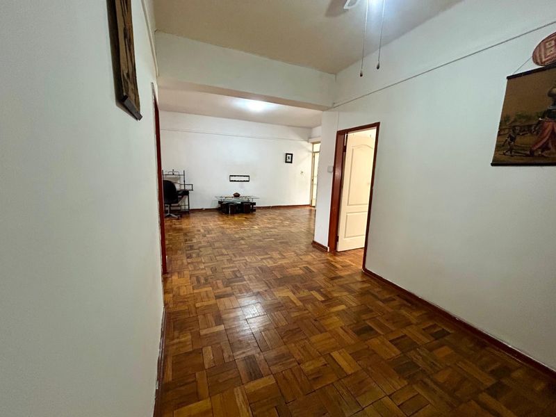Spacious living area featuring traditional parquet flooring and timber door frames, offering a blank canvas for interior design.