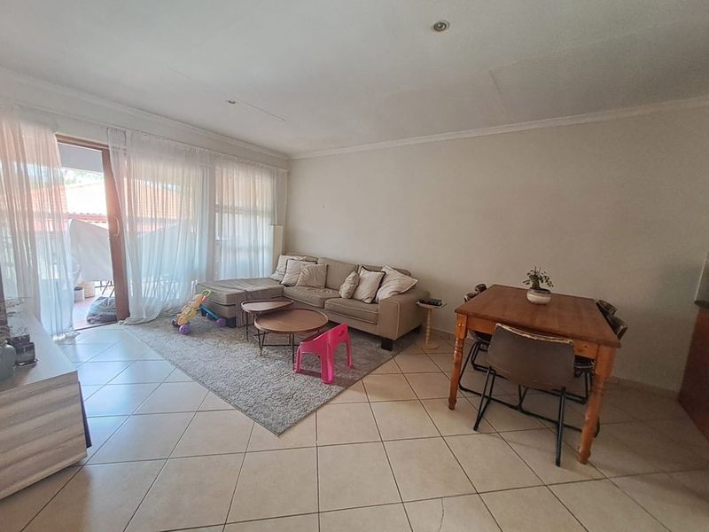 Open plan living and dining area featuring tiled flooring and large sliding glass doors providing access to the patio.