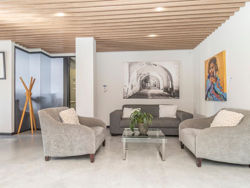 Modern commercial reception or lounge area featuring a stylish slatted timber ceiling, polished concrete floors, and contemporary finishes.
