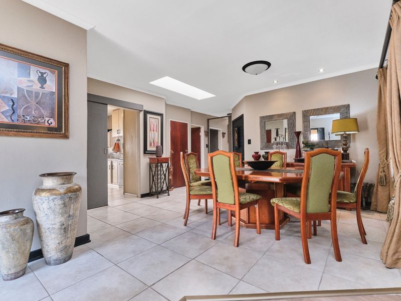 Spacious dining area featuring neutral tiled flooring, a skylight for natural illumination, and direct access to the kitchen area.