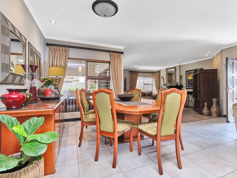 Spacious dining area featuring neutral tiled flooring, recessed lighting, and seamless flow into the adjacent living space.