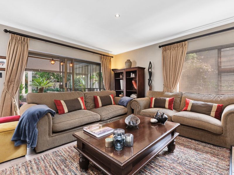 Spacious living room featuring large windows, recessed downlighting, and sliding glass doors that provide seamless access to the outdoor patio area.