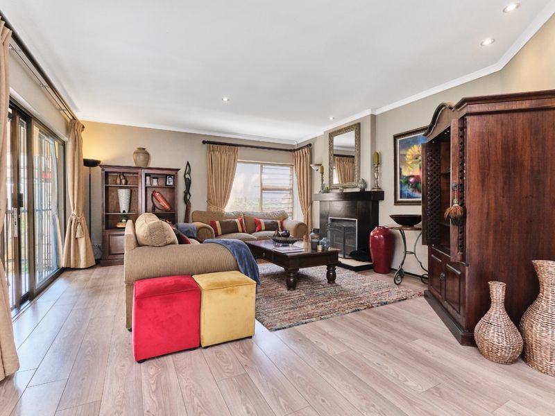 Spacious living room featuring a fireplace, laminate flooring, and large sliding glass doors that provide access to the outdoor area.