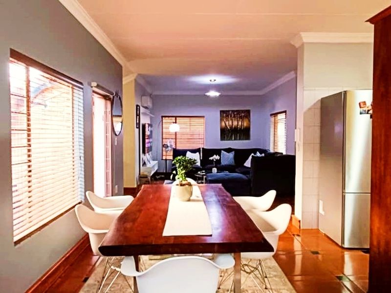 Open-plan living and dining area featuring tiled flooring, coved cornicing, and natural light through venetian blinds.