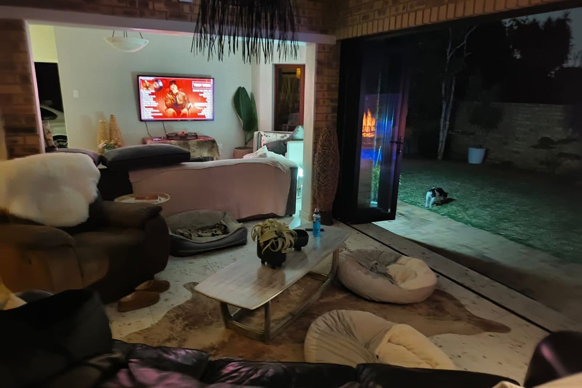 Spacious living area featuring exposed brick walls and large bi-fold doors that open directly onto the rear garden.