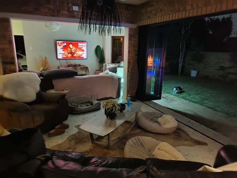 Spacious living area featuring exposed brick walls and large bi-fold doors that open directly onto the rear garden.
