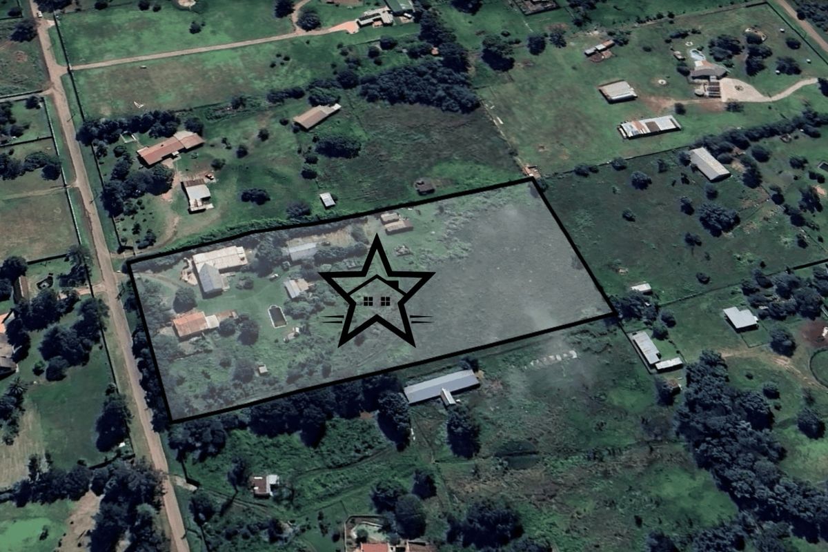 Aerial view of a large residential property plot featuring multiple structures and extensive surrounding land.