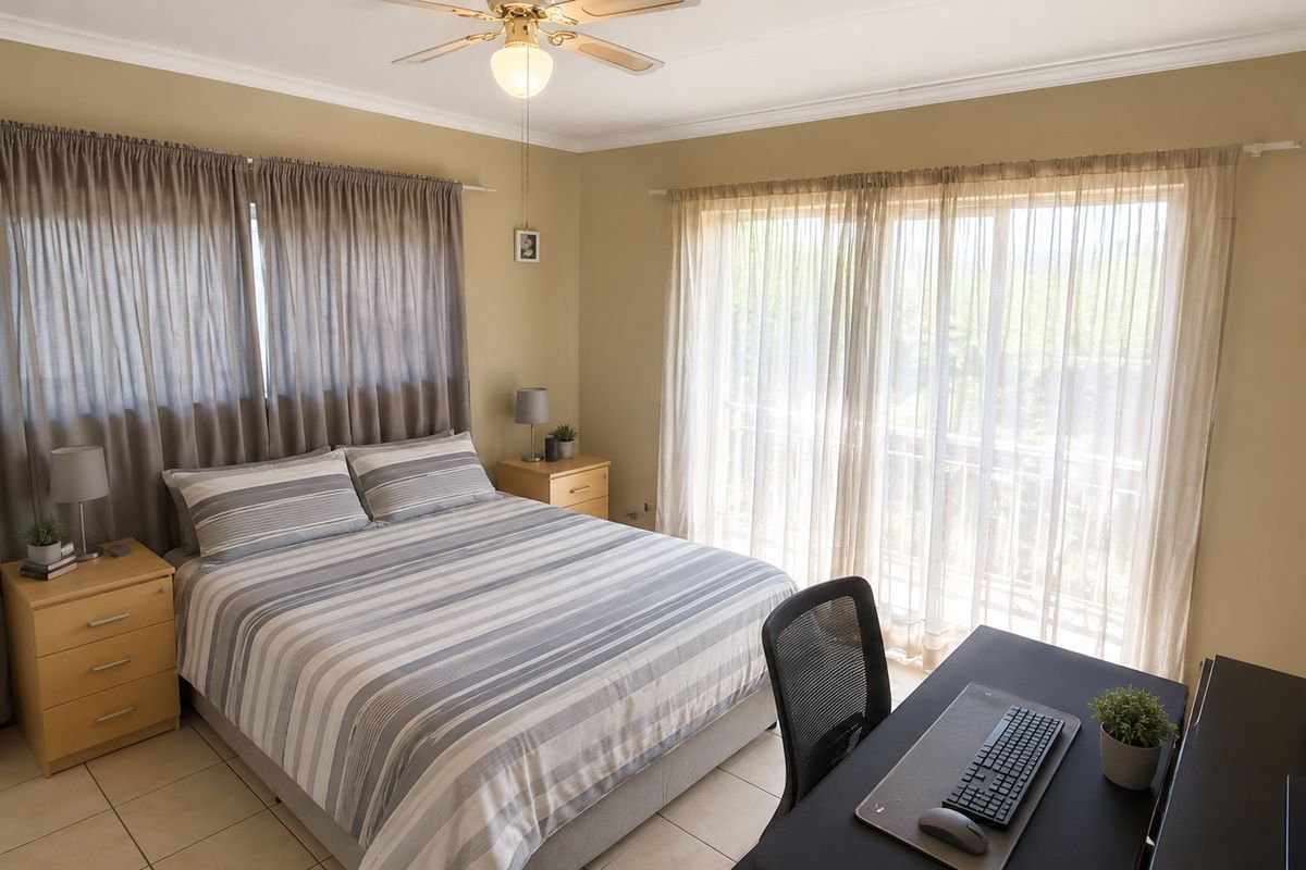 A well-lit bedroom featuring tiled flooring, a ceiling fan, and a sliding glass door providing access to an outdoor area.