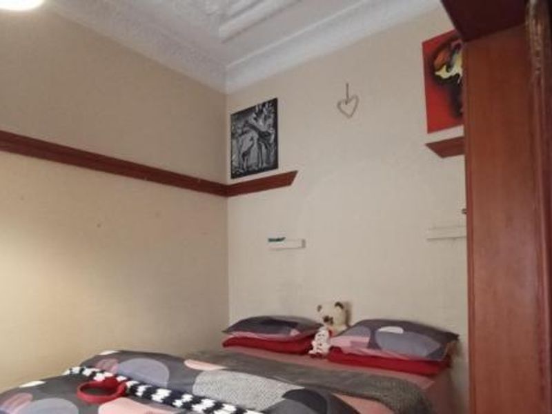 A bedroom featuring traditional picture rails and decorative ceiling cornicing, providing a classic architectural foundation for the space.