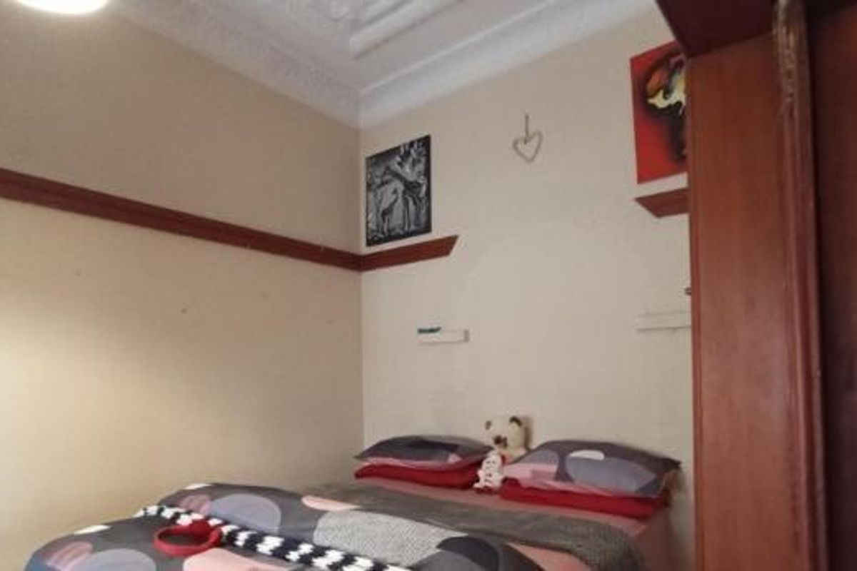A bedroom featuring traditional picture rails and decorative ceiling cornicing, providing a classic architectural foundation for the space.