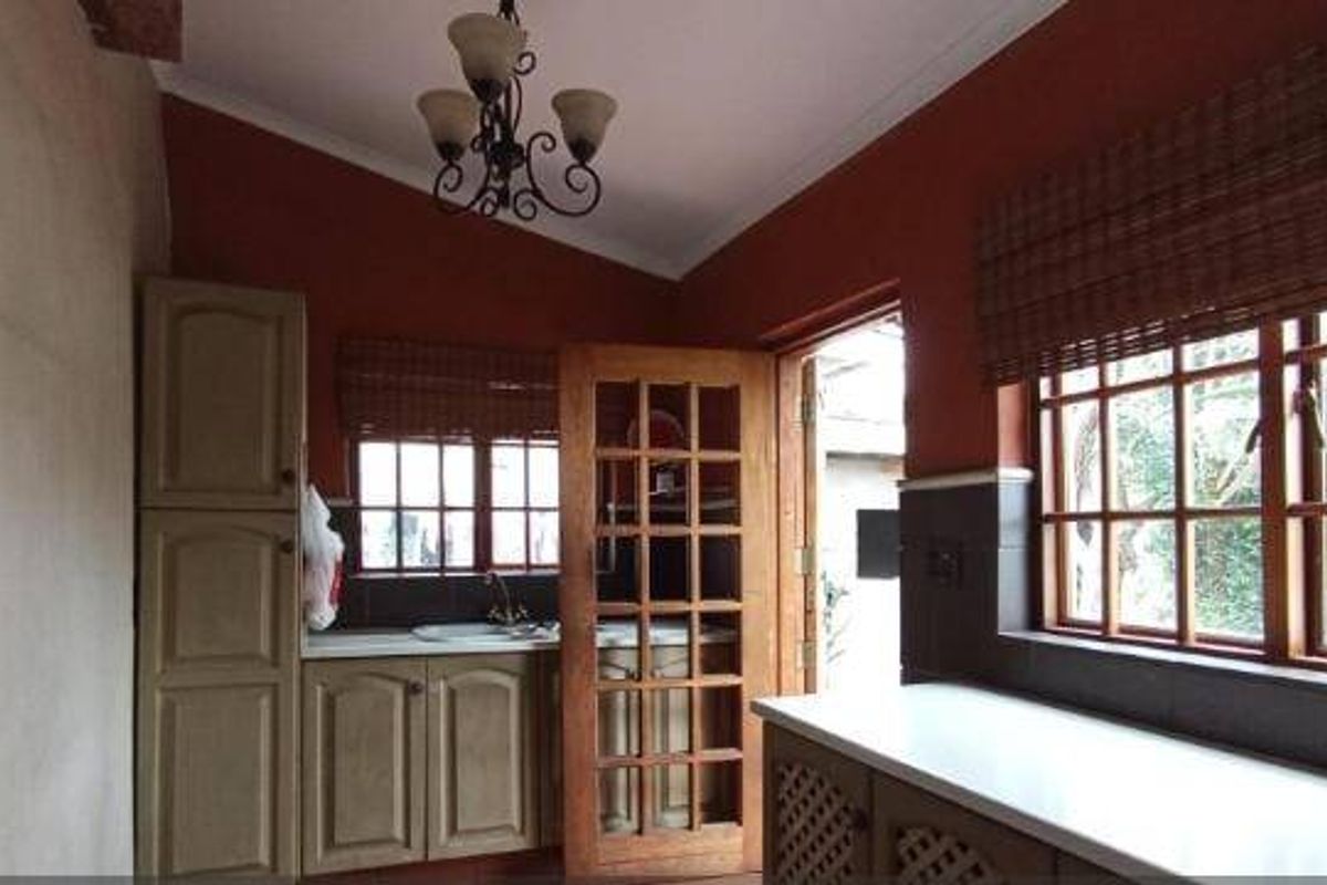 A functional kitchen featuring built-in cabinetry, tiled splashbacks, and timber-framed windows, offering a classic aesthetic with potential for modern updates.