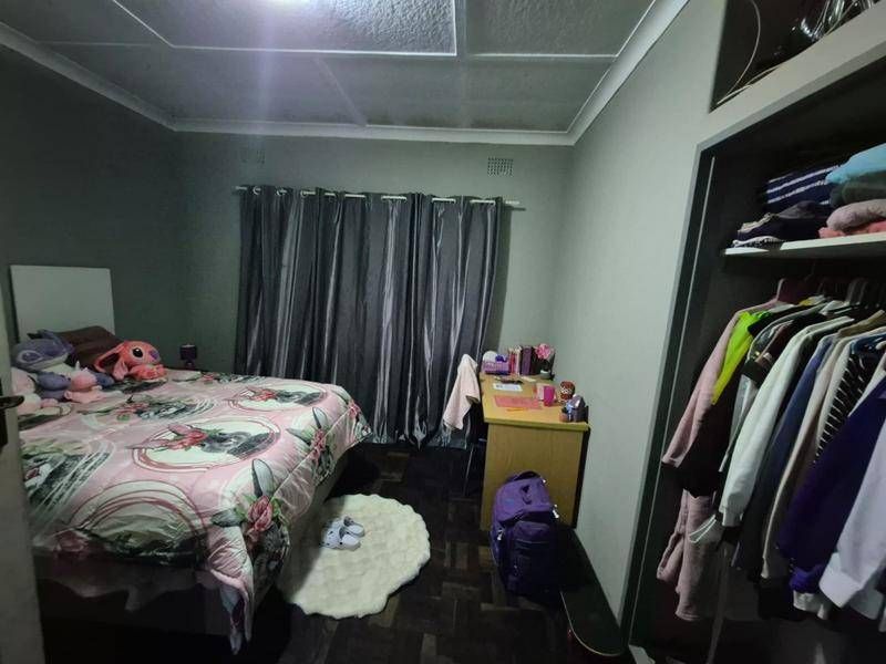 A bedroom featuring parquet flooring, a built-in wardrobe, and a textured ceiling finish.