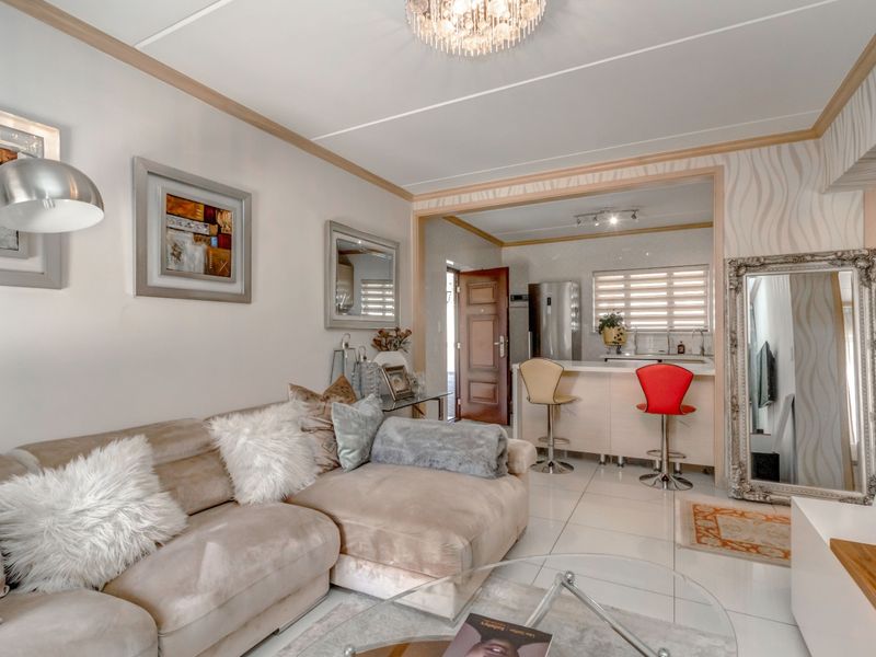 Open plan living area featuring tiled flooring, a breakfast bar counter, and a connected kitchen space with modern finishes.