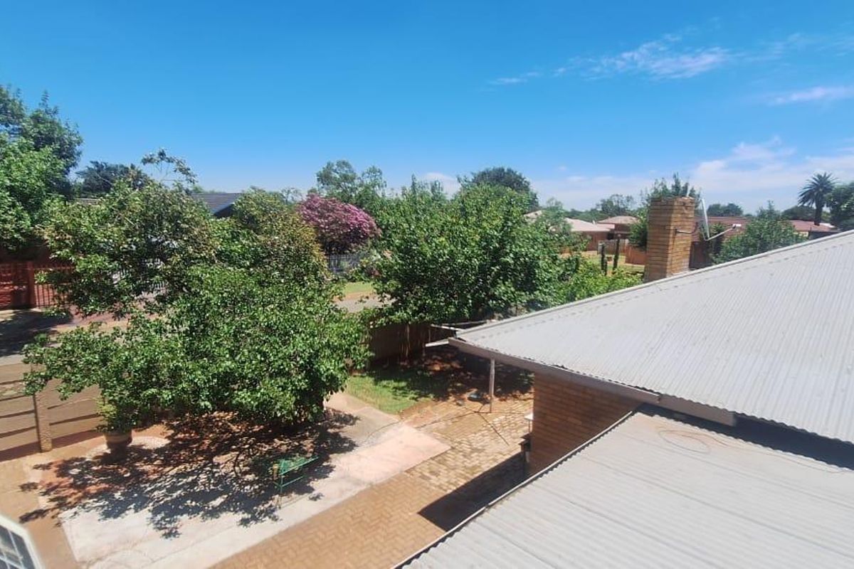An elevated view overlooking the property's rear garden, paved courtyard area, and surrounding neighborhood rooftops.