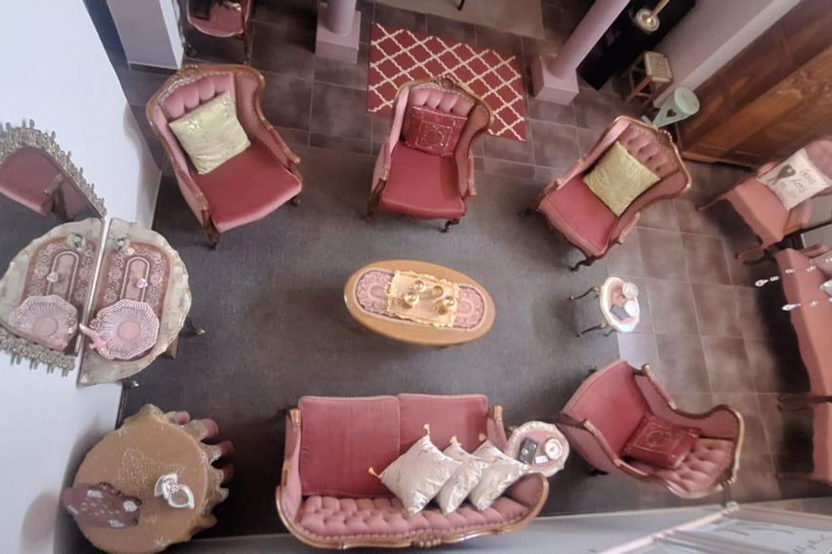 An elevated view of a spacious living area featuring tiled flooring and a high ceiling, providing a clear perspective of the room layout.