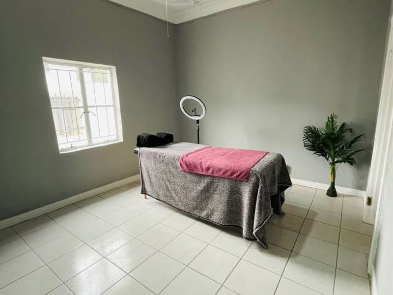 A bedroom featuring decorative ceiling tiles, a ceiling fan, tiled flooring, and a window with security bars.